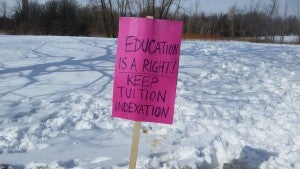 A pink sign in the snow reads "Education is a right! Keep tuition indexation".