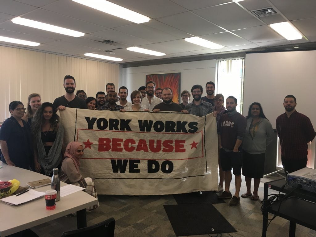 Members of CUPE 3903 stand with a banner reading "York Works Because We Do" at the September 25 bargaining meeting. 